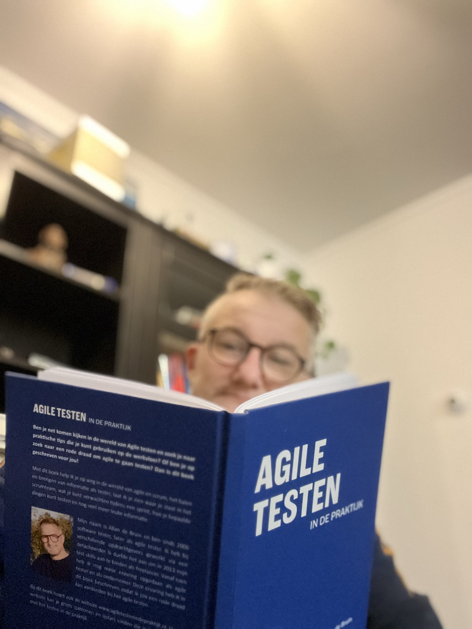 Allan de Bruin die het boek leest van Agile Testen in de Praktijk